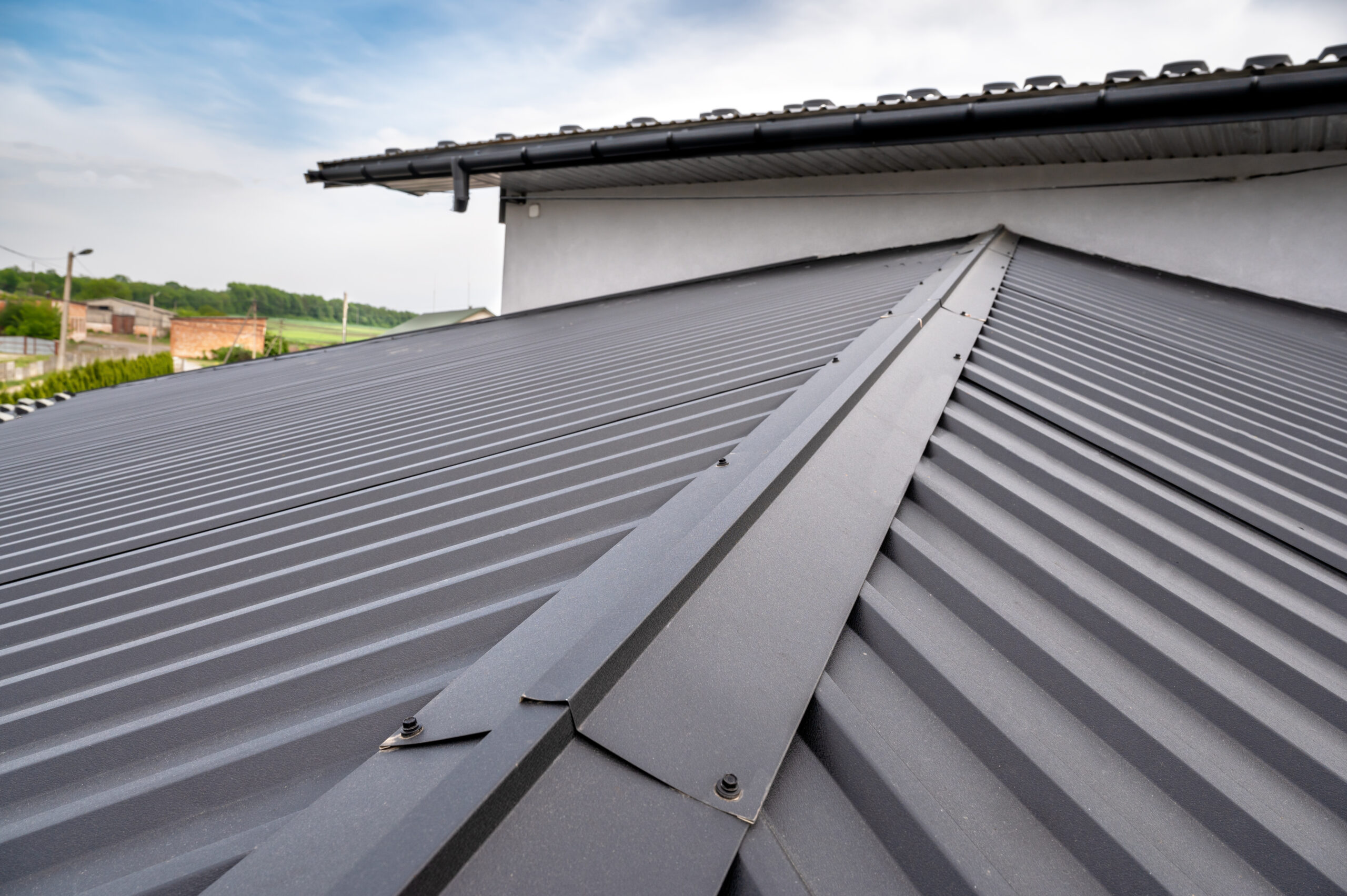A close-up image a metal roofing system, showing a gutter on the side of the house