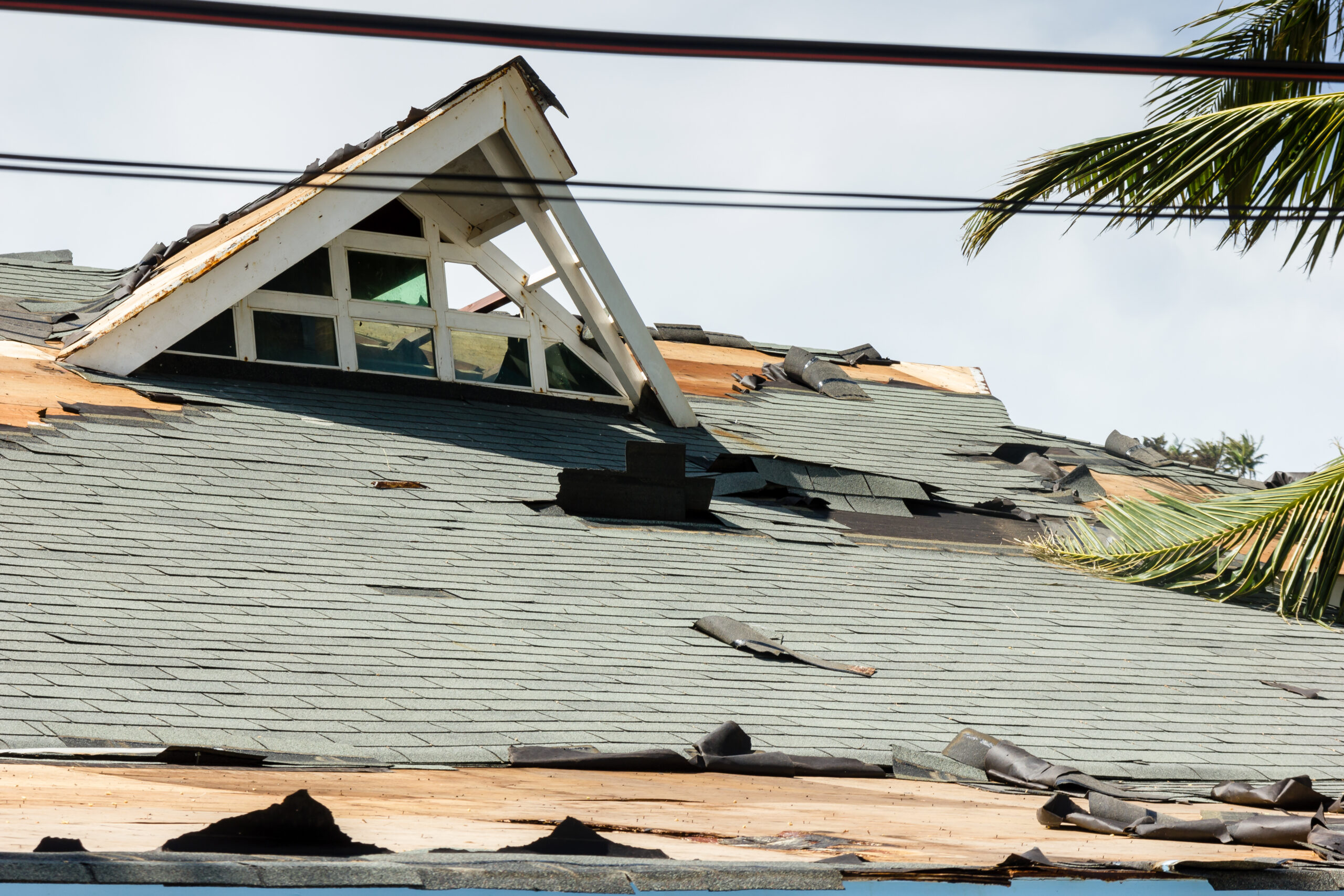 A residential roof damaged by a passing hurricane