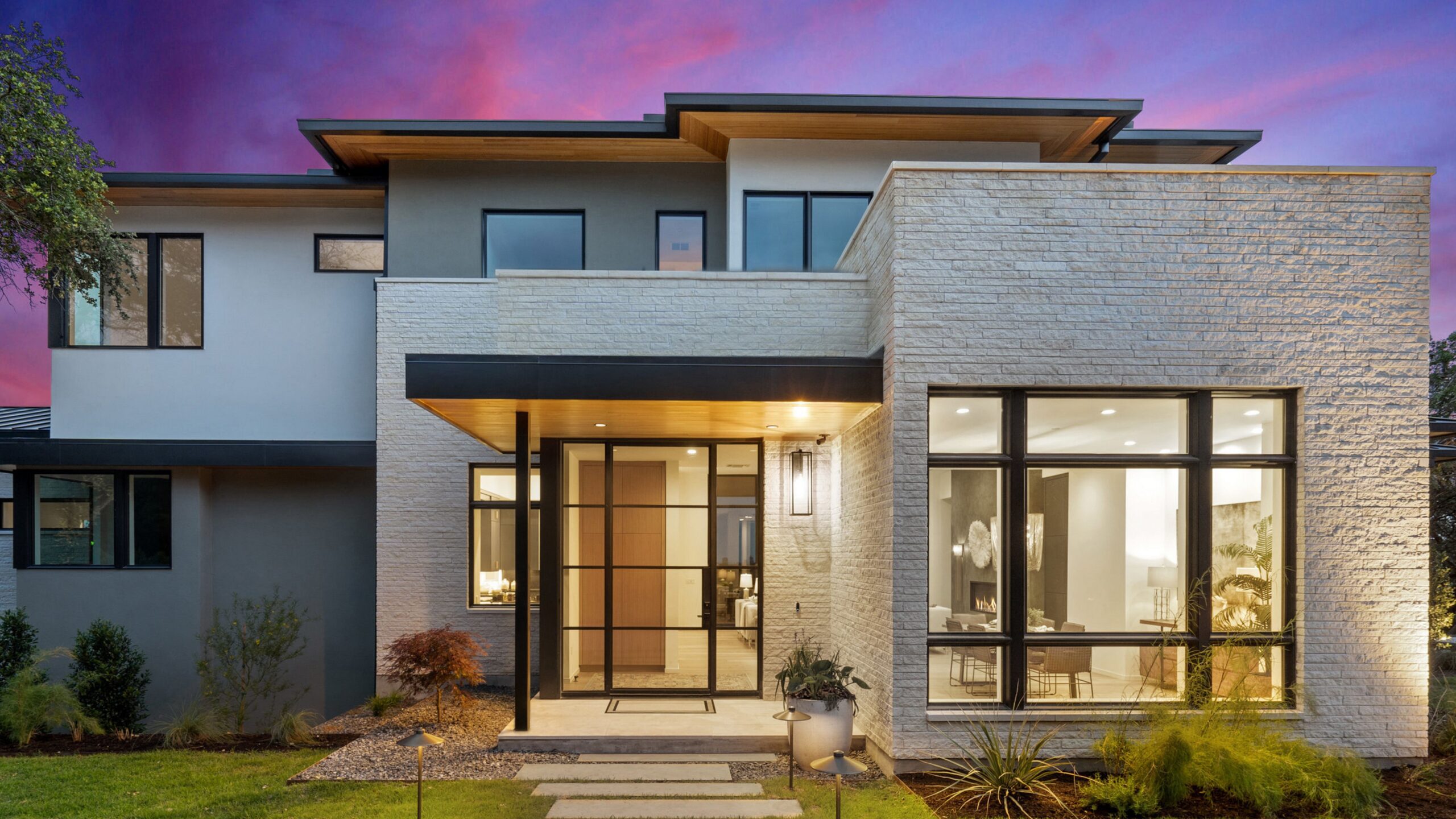 Luxury modern home exterior with stone siding and black flat roof