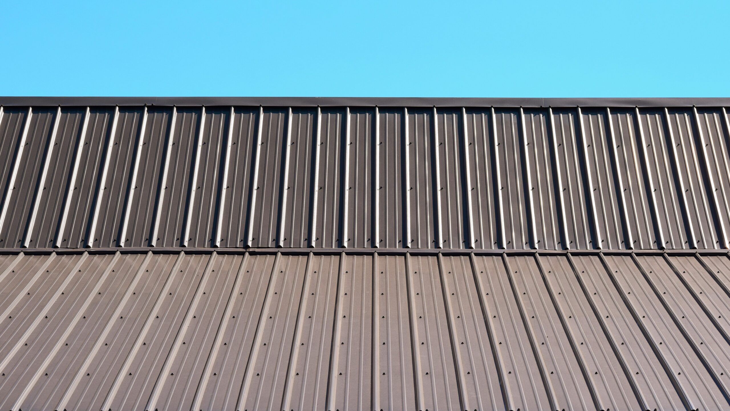 Brown metal roof with a sky view behind it