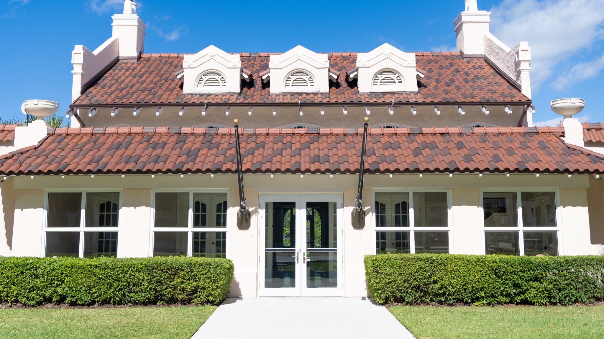 Beautiful Florida home with white interior and light and dark brown checkered Spanish tile roof