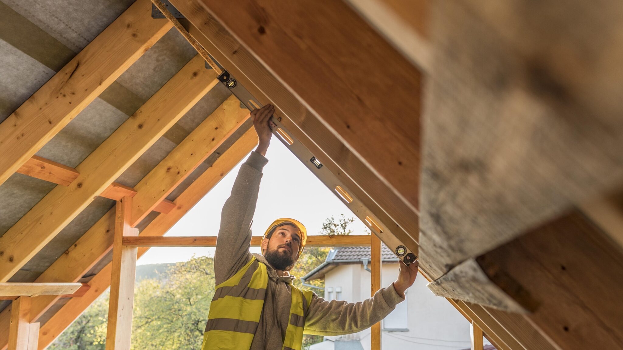Male roofer preparing to use an electric drill to repair a stone-coated steel roof