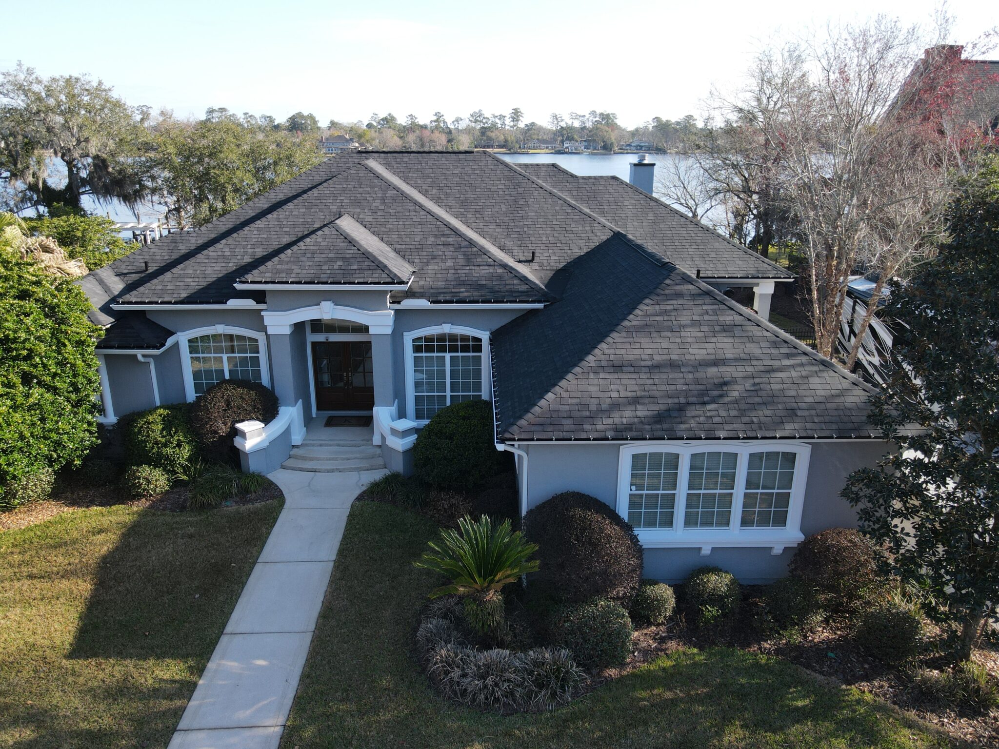 Aerial view of large residential home with gray asphalt roof