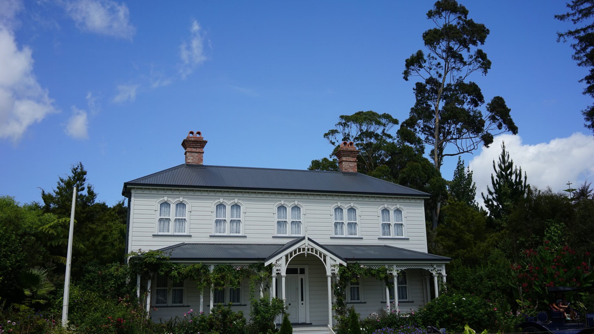 Beige colored home with grey asphalt shingle roof and paved driveway