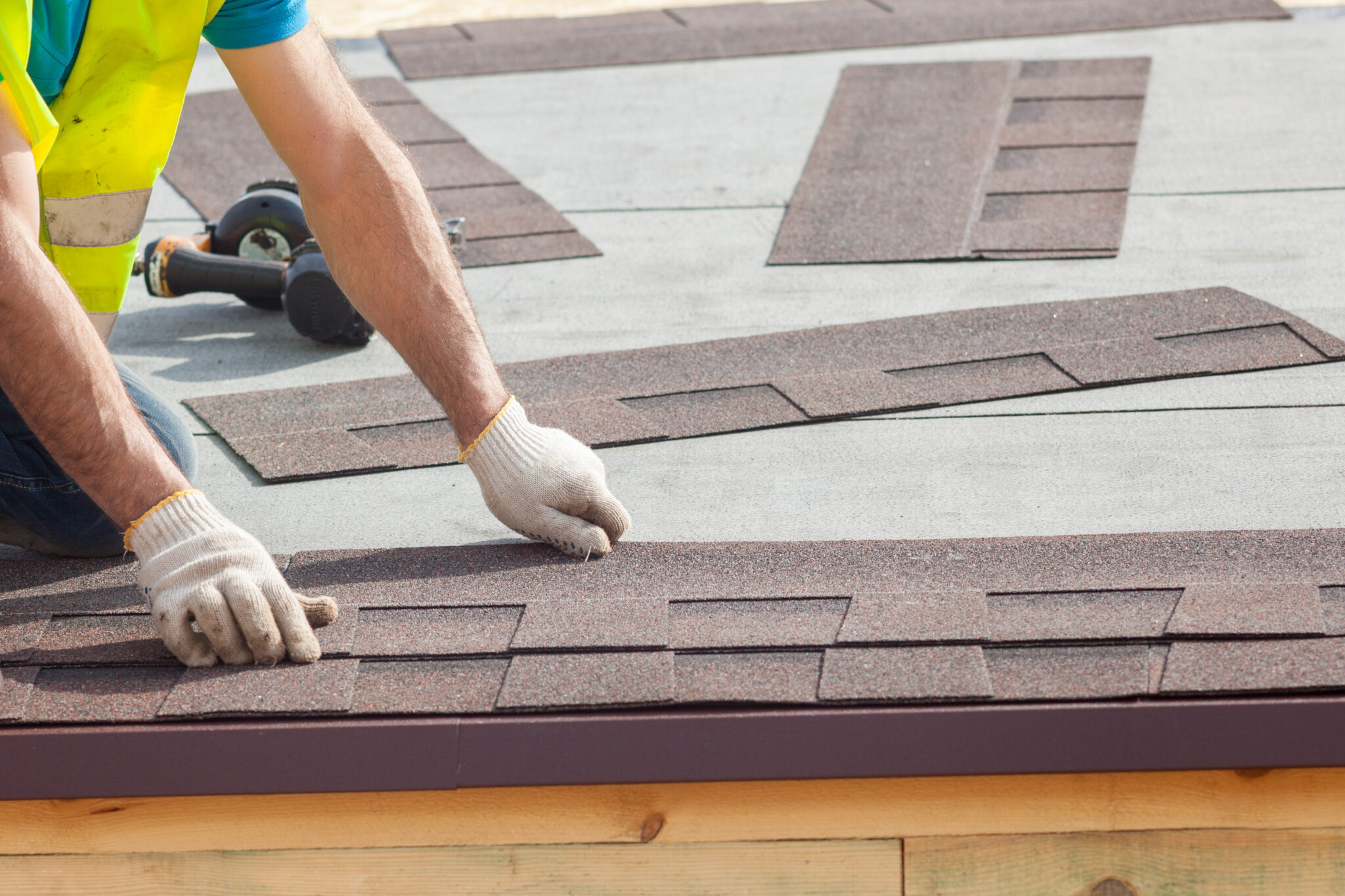 Image of a roofer installing shingles on a house