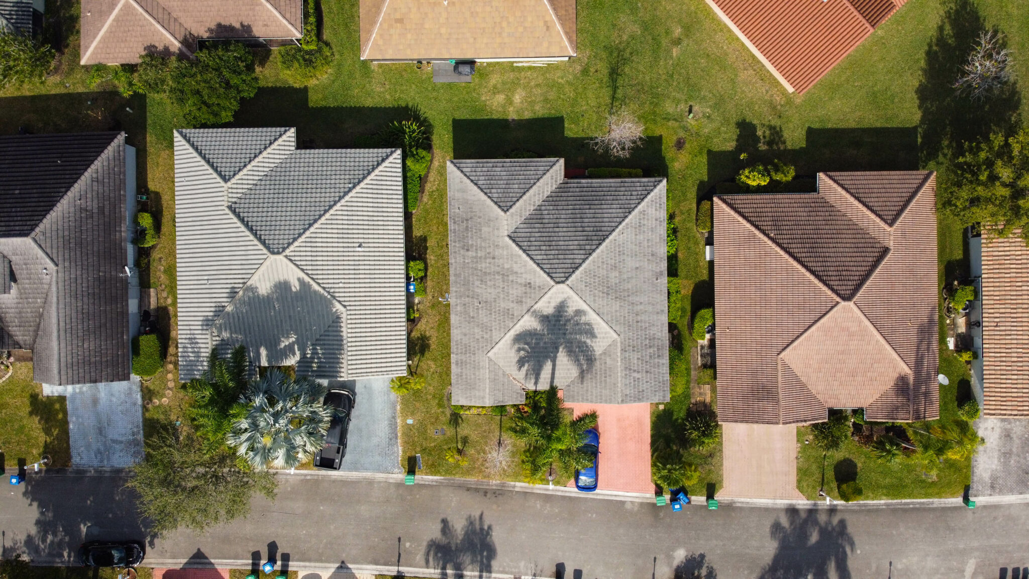 Aerial view of several residential homes with green lawns and trees