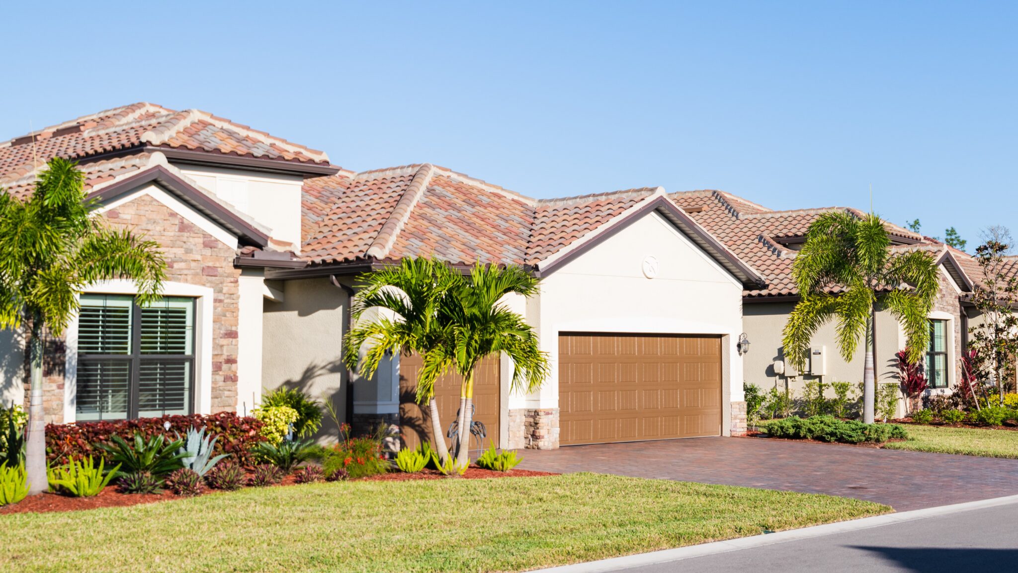 House in Central Florida with tile roof, white siding, and palm trees in front yard
