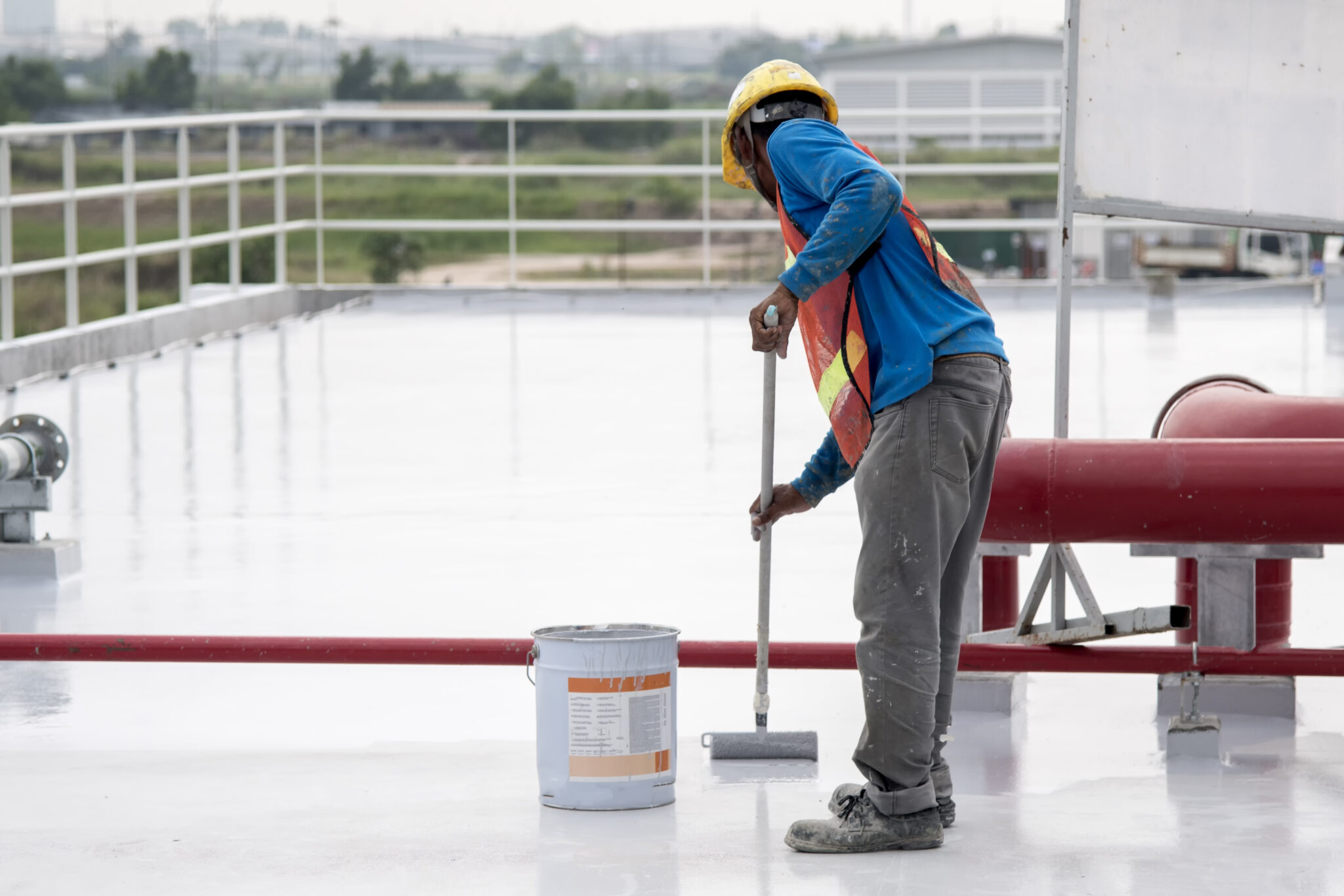 Image of a man adding a PVC roof coating on a commercial building