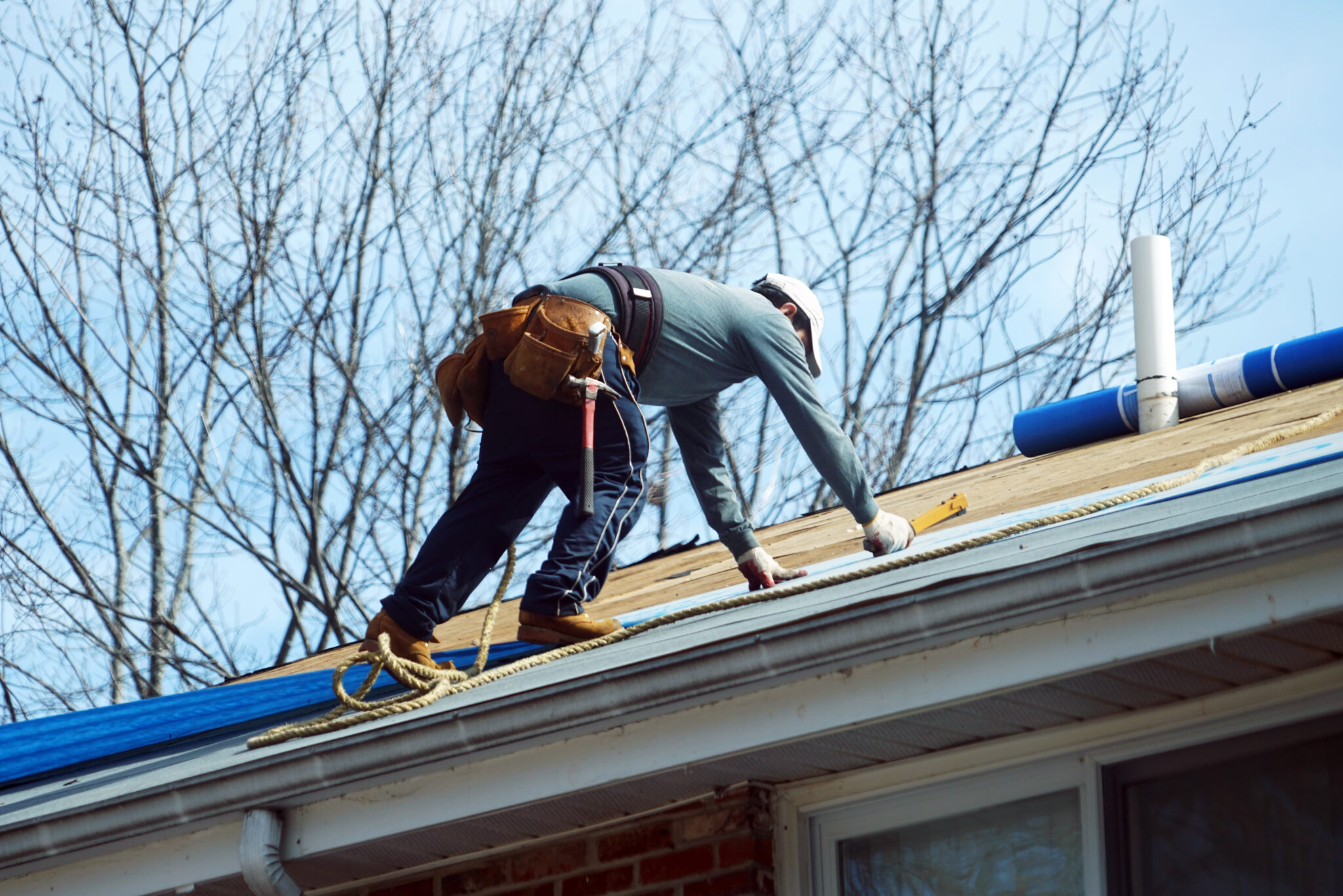 Roofing contractor repairing a damaged roof