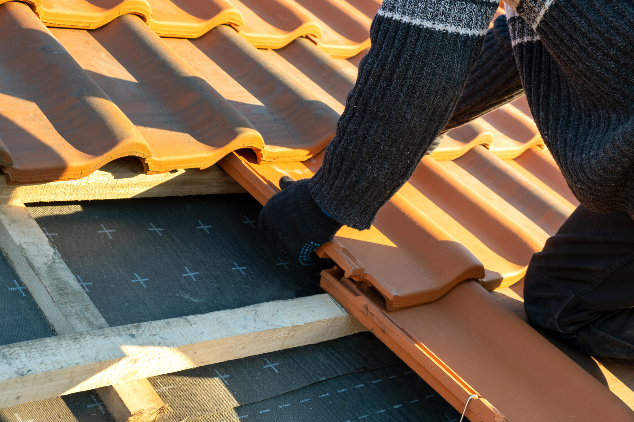 A roofer installs quality Spanish tiles on a Central Florida roof.
