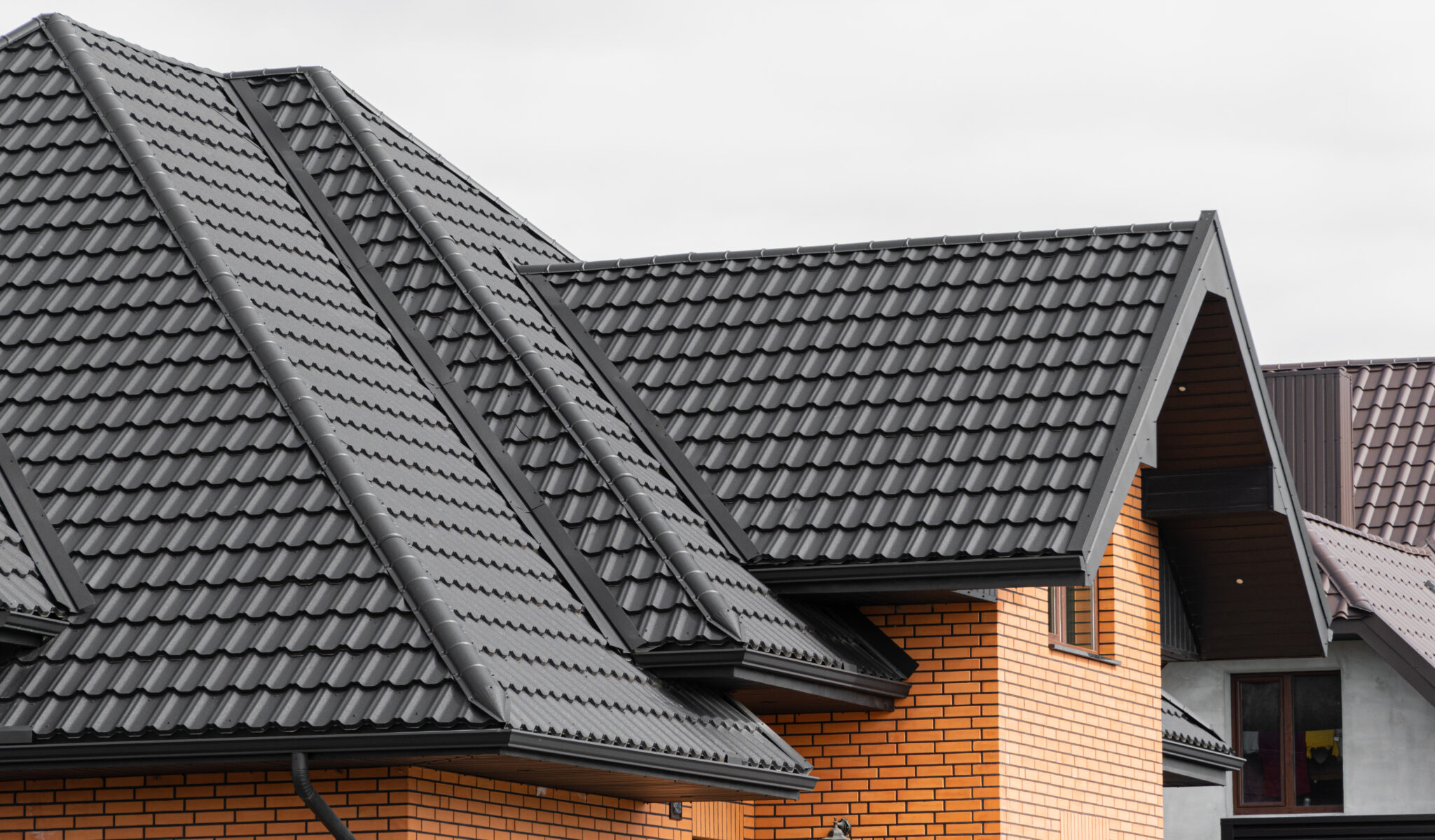 A beautiful light brick home with a contrasting black roof