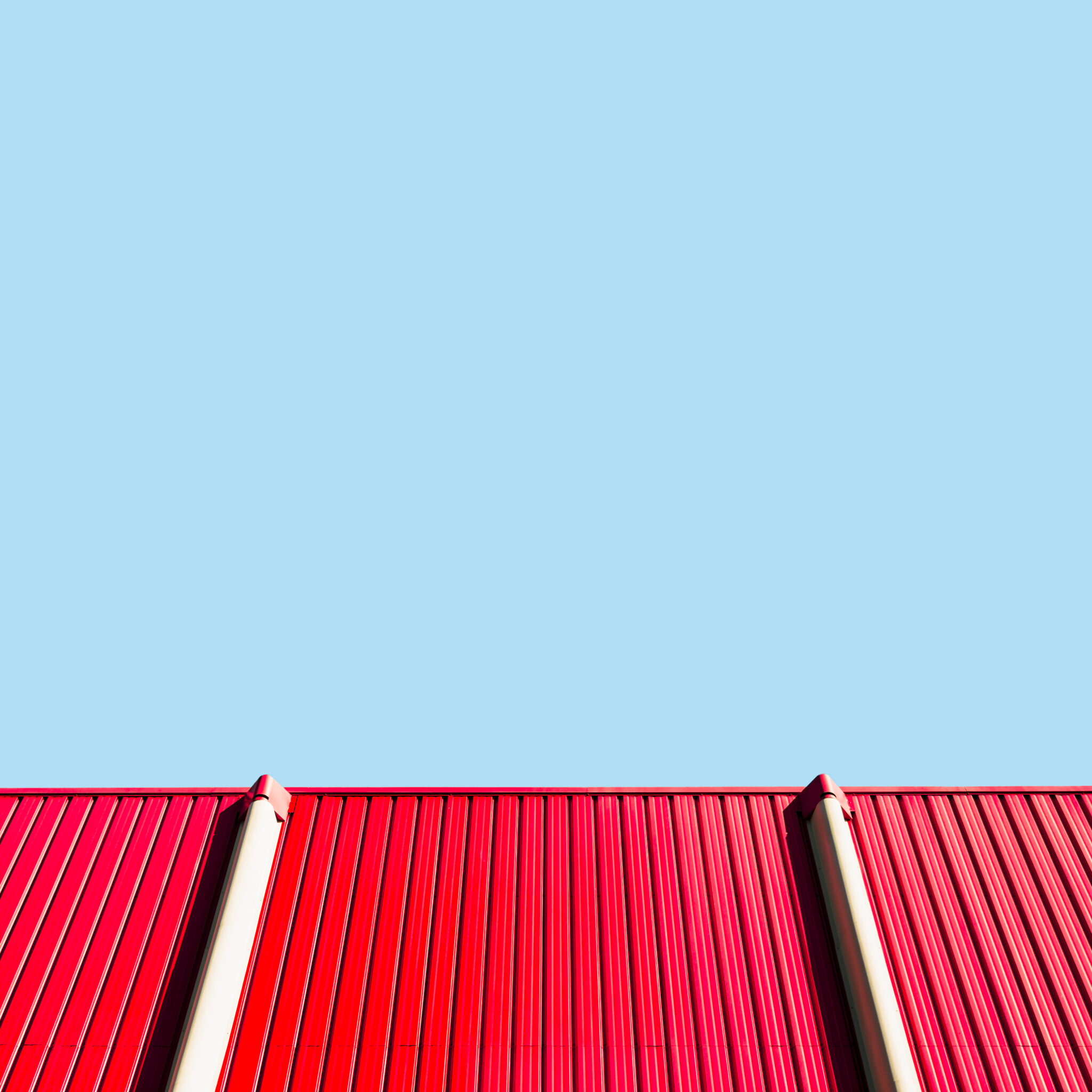 Red metal roof outline against blue sky