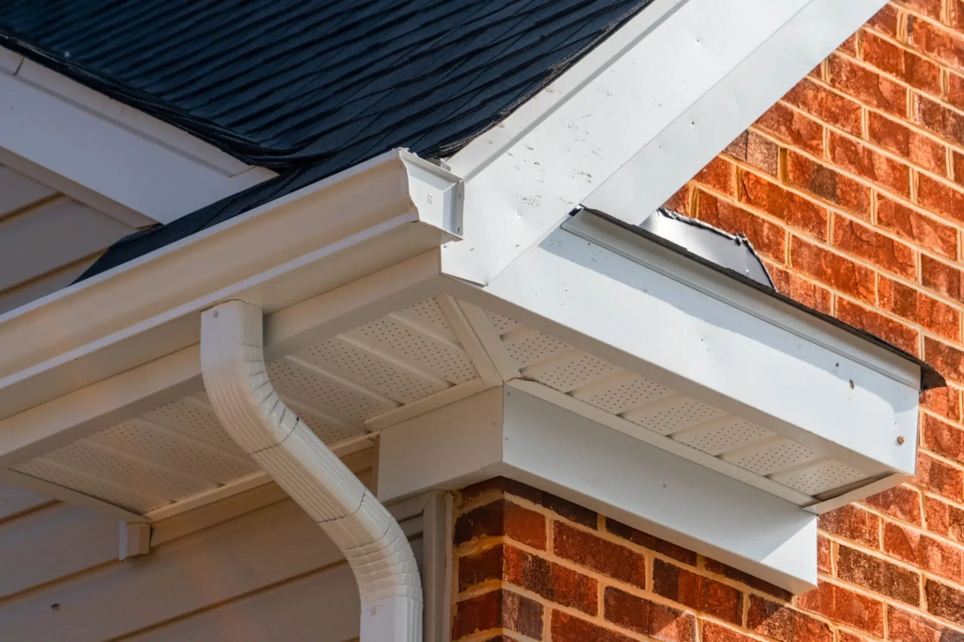 White soffit and gutters on a brick house install by roofing contractors In Fernandina Beach, FL | Universal Roofing & Contracting