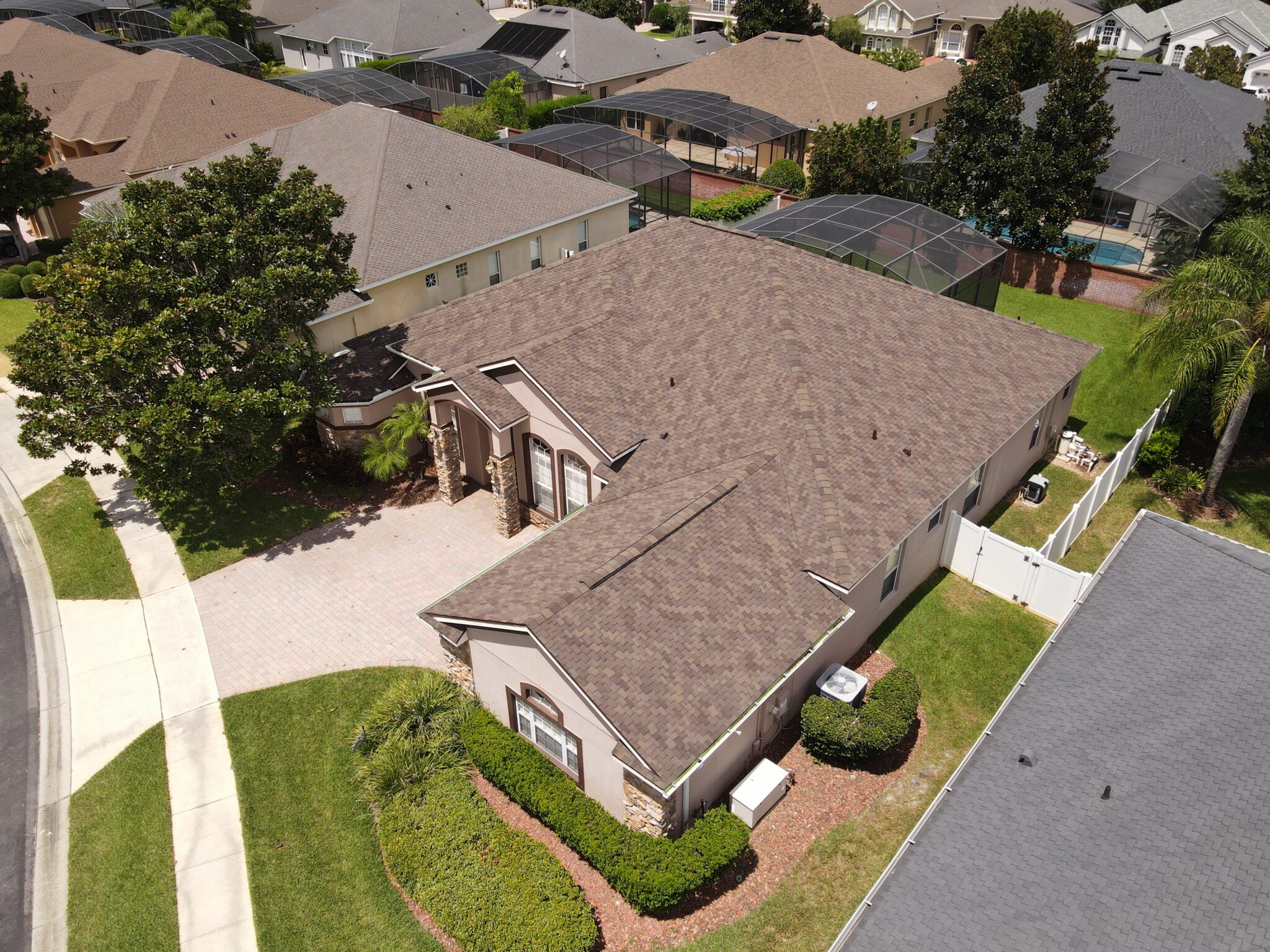 A high-angle shot of a fresh asphalt roof on a large residential property