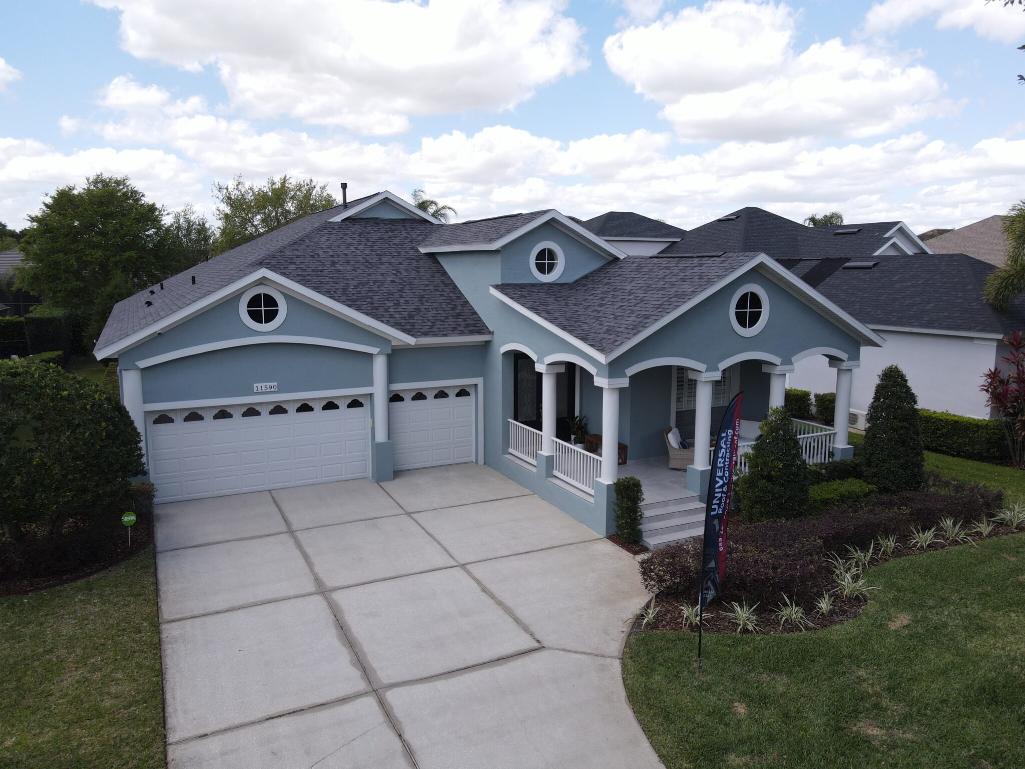 Dark gray asphalt roof on light blue home