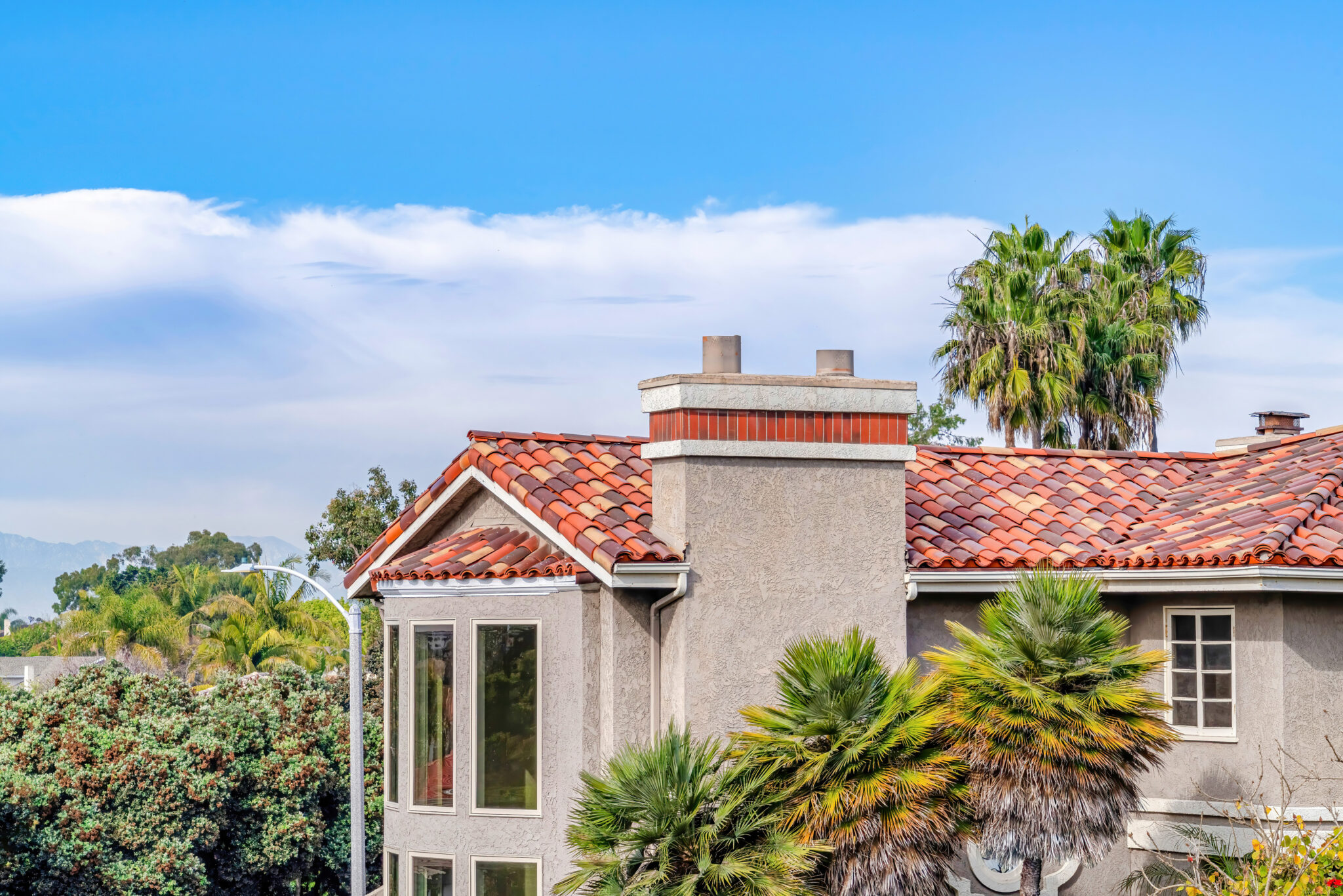 Tan house with Spanish tile roof installed